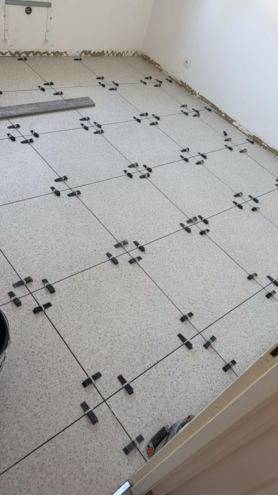 Pose de carrelage au sol avec croisillons, pièce lumineuse