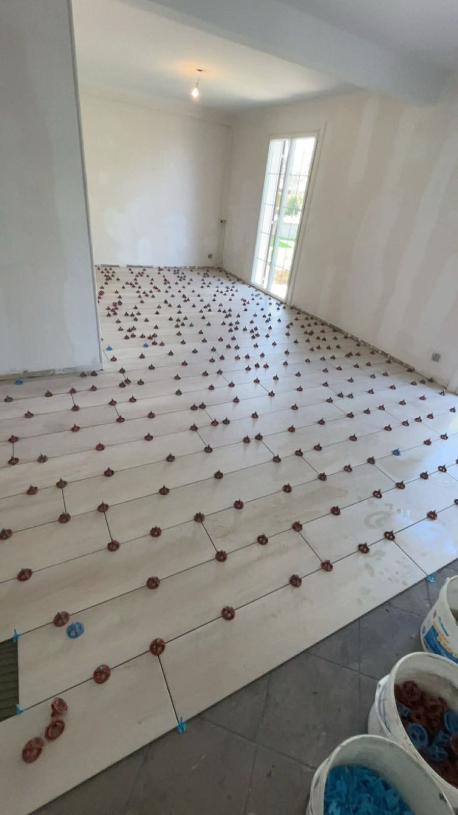 Pièce entière en cours de carrelage avec système de nivellement