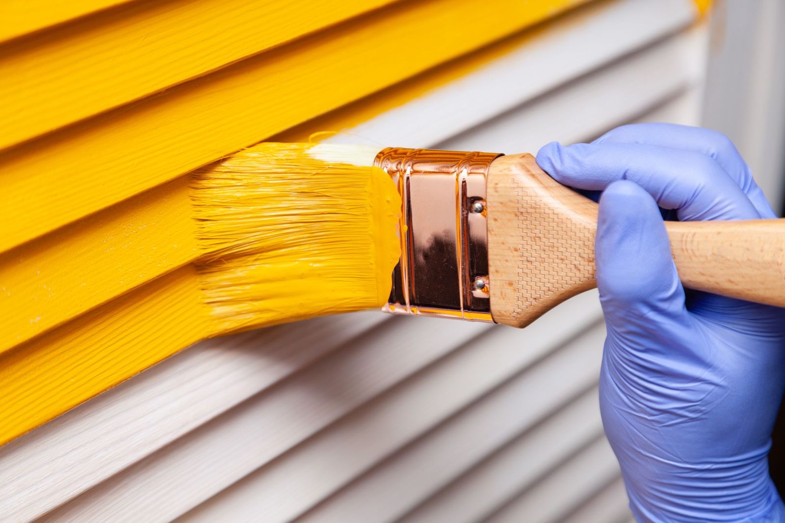 Application de peinture jaune sur un bardage extérieur